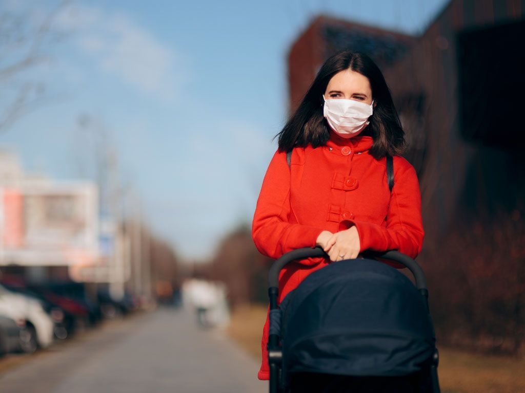 Mother Wearing Face Mask Walking Baby in Stroller